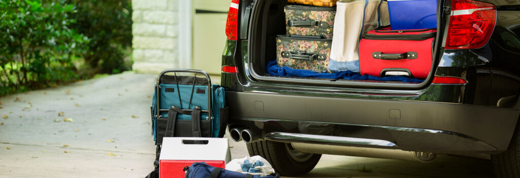 Packed suitcases and cooler in trunk of car